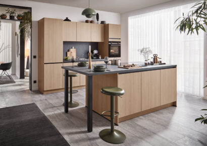 Moderne Holzküche mit Kücheninsel und schwarzer Arbeitsfläche bei Ortmann & Winter in Bochum